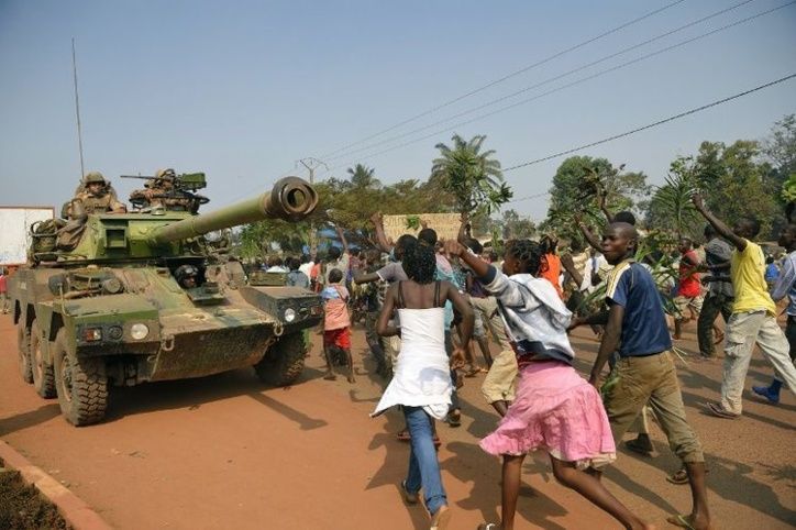 Des manifestants anti-Séléka, hostiles à Michel Djotodia, passent près d'un blindé français le 10 janvier à Bangui. (Photo Er