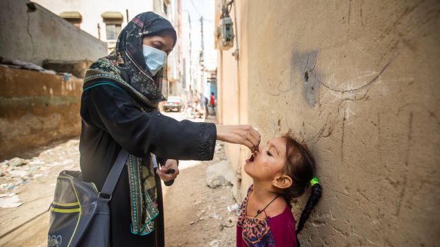 Samreen (3 ans), est vaccinée par Samina (27 ans), vaccinatrice contre la polio, à Qayyumabad, Korangi, Karachi, Pakistan, le