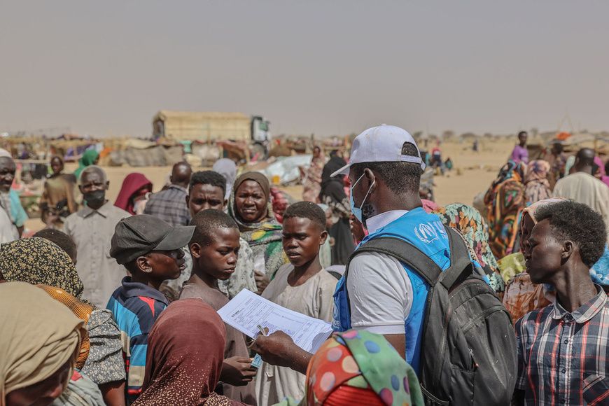 © UNHCR/Caitlin Kelly Un employé de l'ONU au Tchad s'entretient avec des réfugiés nouvellement arrivés du Soudan. Des millier