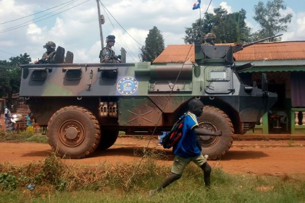 Un groupe de soldats français de la mission Sangaris passe près d'un enfant à Bangui, en Centrafrique, le 13 juillet 2014 / ©