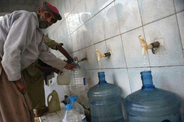 Un homme remplit des bouteilles d'eau dans une station de traitement à Islamabad, le 14 décembre 2017 / © AFP/Archives / Faro