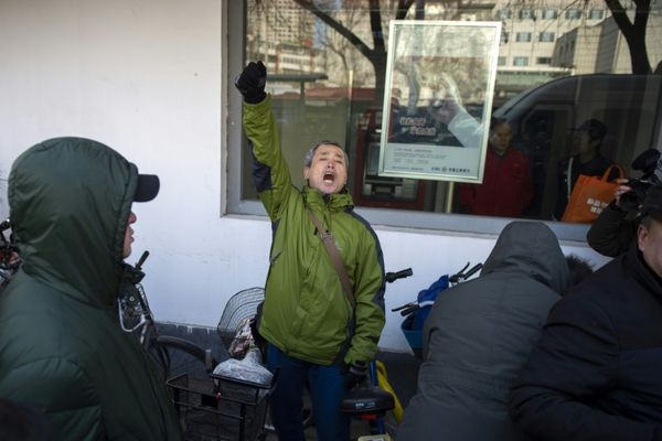 Le militant Yang Chunlin (c) crie son soutien à Me Wang Quanzhang devant le tribunal de Tianjin où se déroule le procès de l'