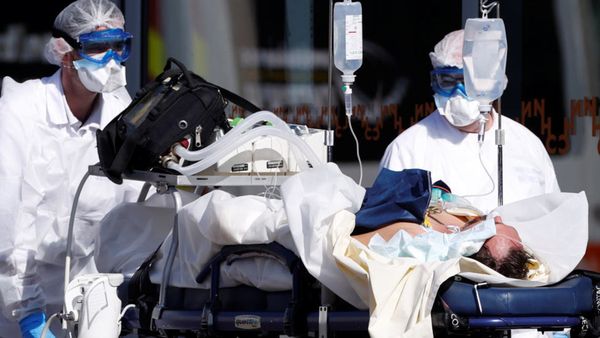 L'équipe de sauvetage française SMUR portant des combinaisons de protection transporte un patient à l'hôpital universitaire d