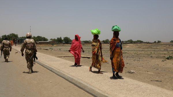 Des femmes passent devant des soldats sur un pont séparant le Cameroun et le Nigéria, à Gamboru Ngala, Borno, Nigéria, le 27 