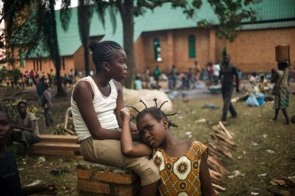 Des habitants se regroupent dans les jardins de l'archevêché à Bangui, le 8 décembre 2013, pour échapper à la violence. (Phot
