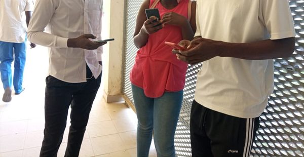 Des jeunes manipulent leurs smartphones. Illustration © Alwihda Info