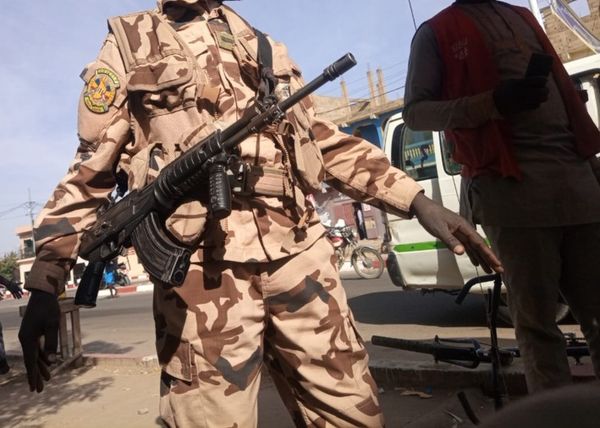 Un militaire de la garde présidentielle renvoie des vendeurs ambulants pour sécuriser le passage du cortège du président de t