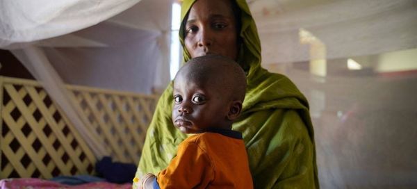Une mère amène son enfant malade dans un centre de santé soutenu par l'UNICEF dans le nord du Darfour, au Soudan. © UNICEF/Mo