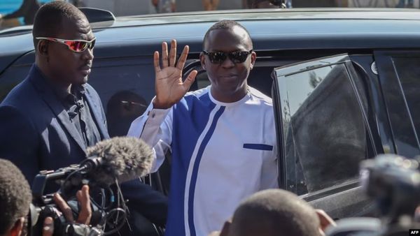 Le nouveau Premier ministre Succès Masra (au centre) salue en arrivant dans un bureau de vote pour voter lors du référendum c