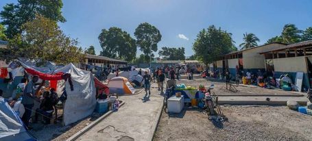 © IOM/Antoine Lemonnier. Un groupe de personnes déplacées hébergées dans une école du centre de Port-au-Prince, sur le site J