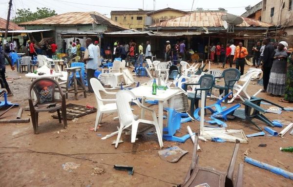 Des gens observent le site d'un précédent attentat à Sabon Gari, près de Kano (nord-est du Nigeria), le 30 juillet 2013 (Phot