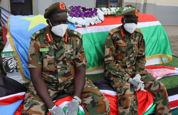 Les forces de sécurité du Soudan du Sud sont assises près du cercueil du général David Majur Dak, commandant des Forces de dé