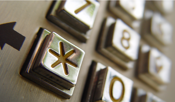A macro shot of a payphone, focused on the asterisk, reflecting how we add footnotes to our grief even as we work toward acceptance.