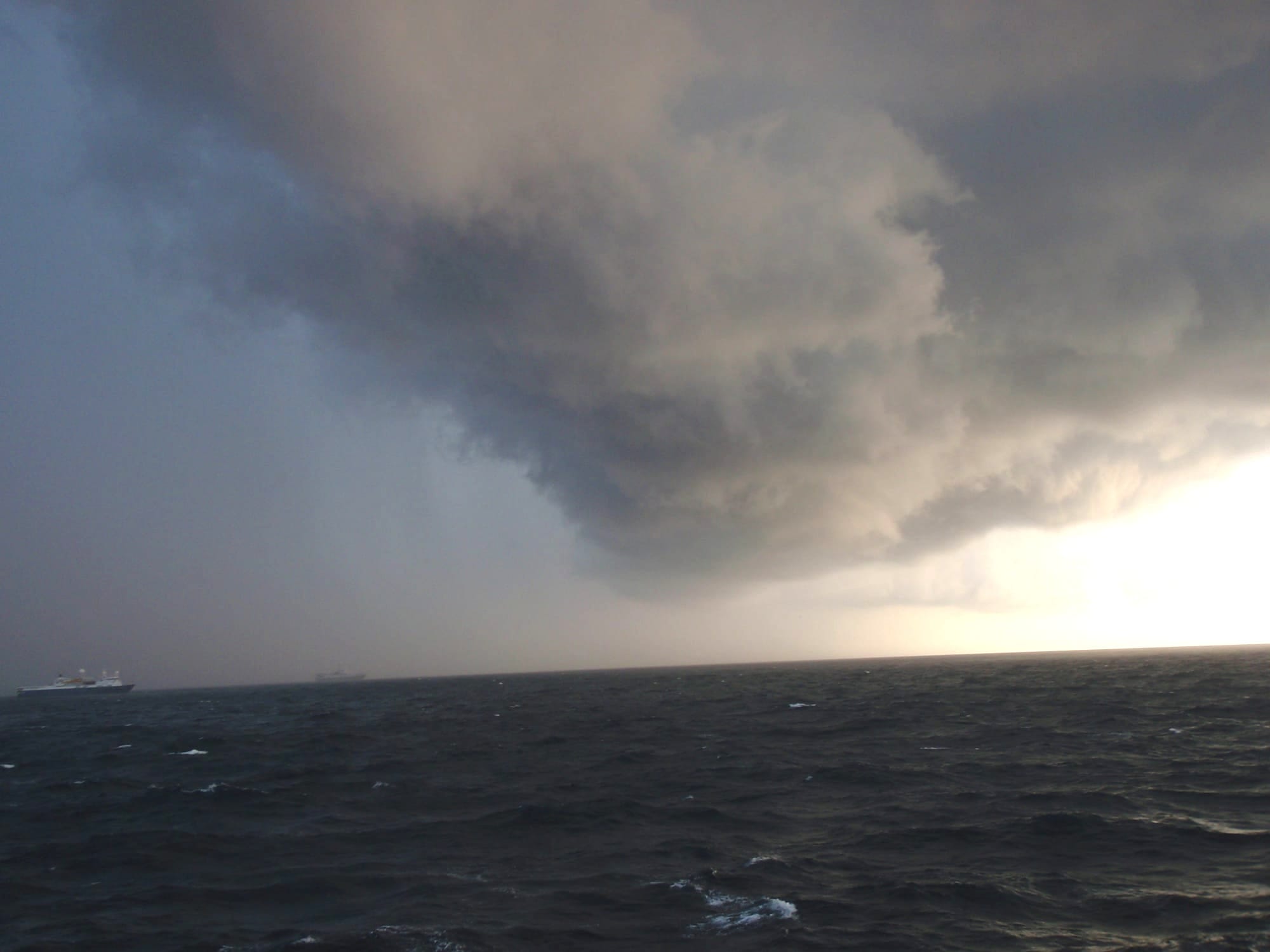 Dark storm clouds gathering over a rough, grey sea in the Gulf of Mexico, seen from a vessel offshore.