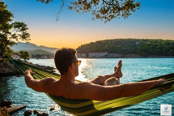 Man enjoying a peaceful lakeside sunset from a hammock, representing financial independence and early retirement.