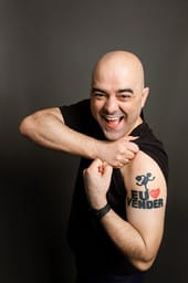 imagem do palestrante de vendas Leandro Branquinho mostrando a tatuagem que tem no braço. Na tatuagem tem o escrito "Eu Amo Vender"