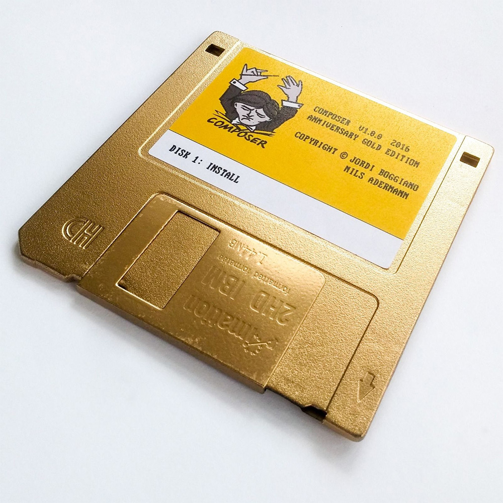 Golden floppy disk with label containg Composer logo and the text "COMPOSER v1.0.0 2016 ANNIVERSARY GOLD EDITION COPYRIGHT Jordi Boggiano, Nils Adermann DISK 1: INSTALL"