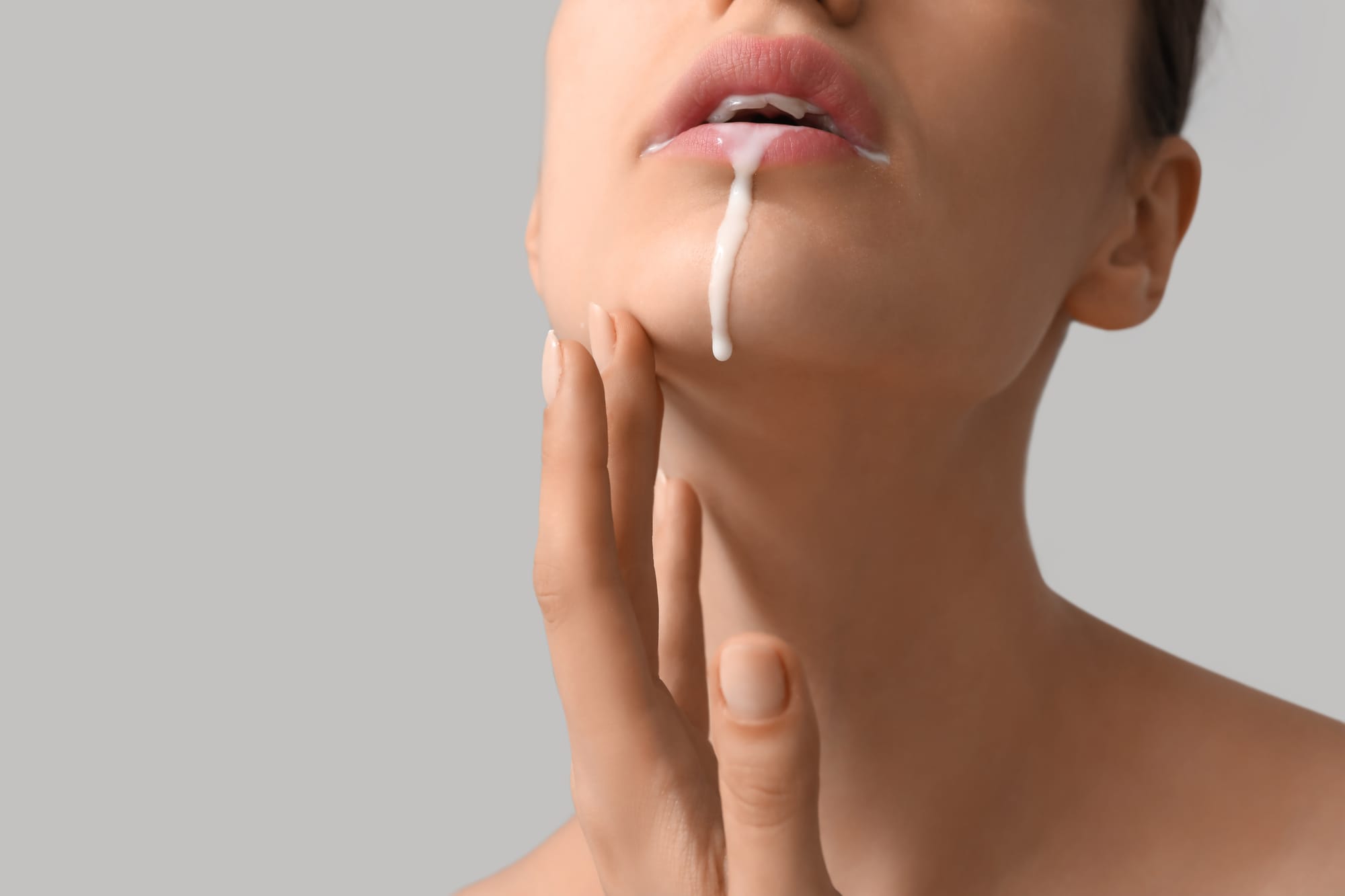 Yogurt dripping down woman's lips