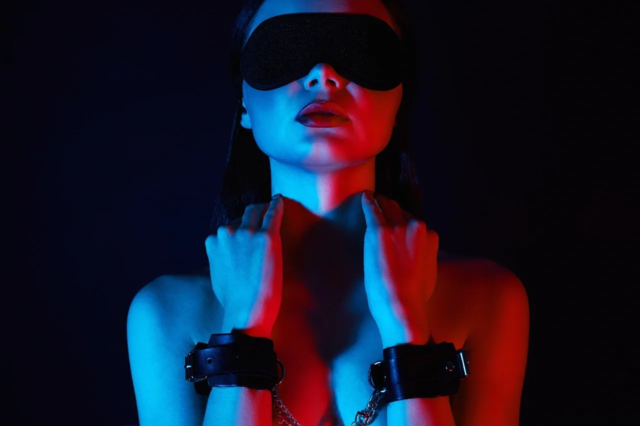 Blindfolded woman exploring sensory play and power dynamics without penetration