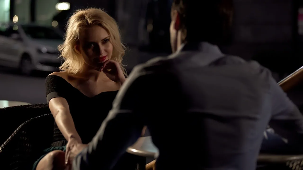 Blonde woman at night cafe giving flirty look to male friend - testing if your guy friend is attracted to you