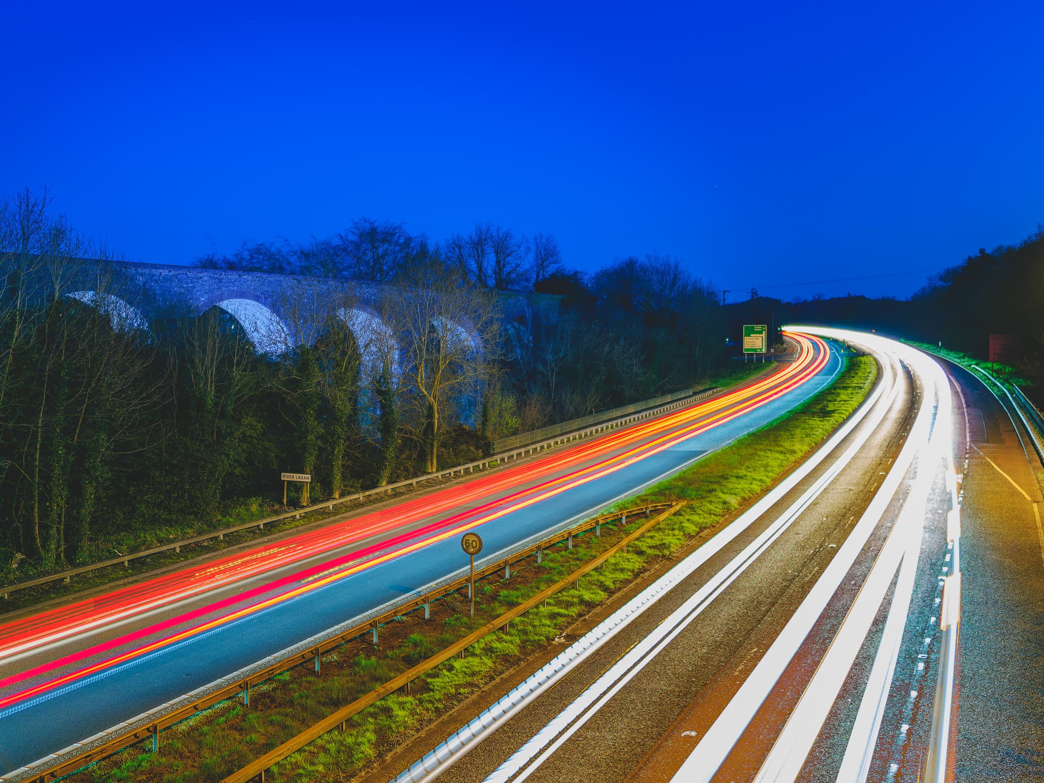 Car light trails passing an disused viaduct