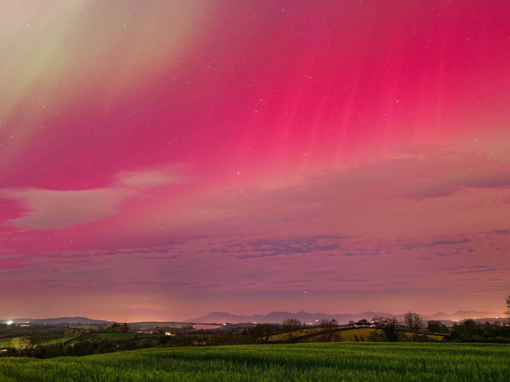 A pink sky and stars beaming over the Mourne Mountains on the horizon. 