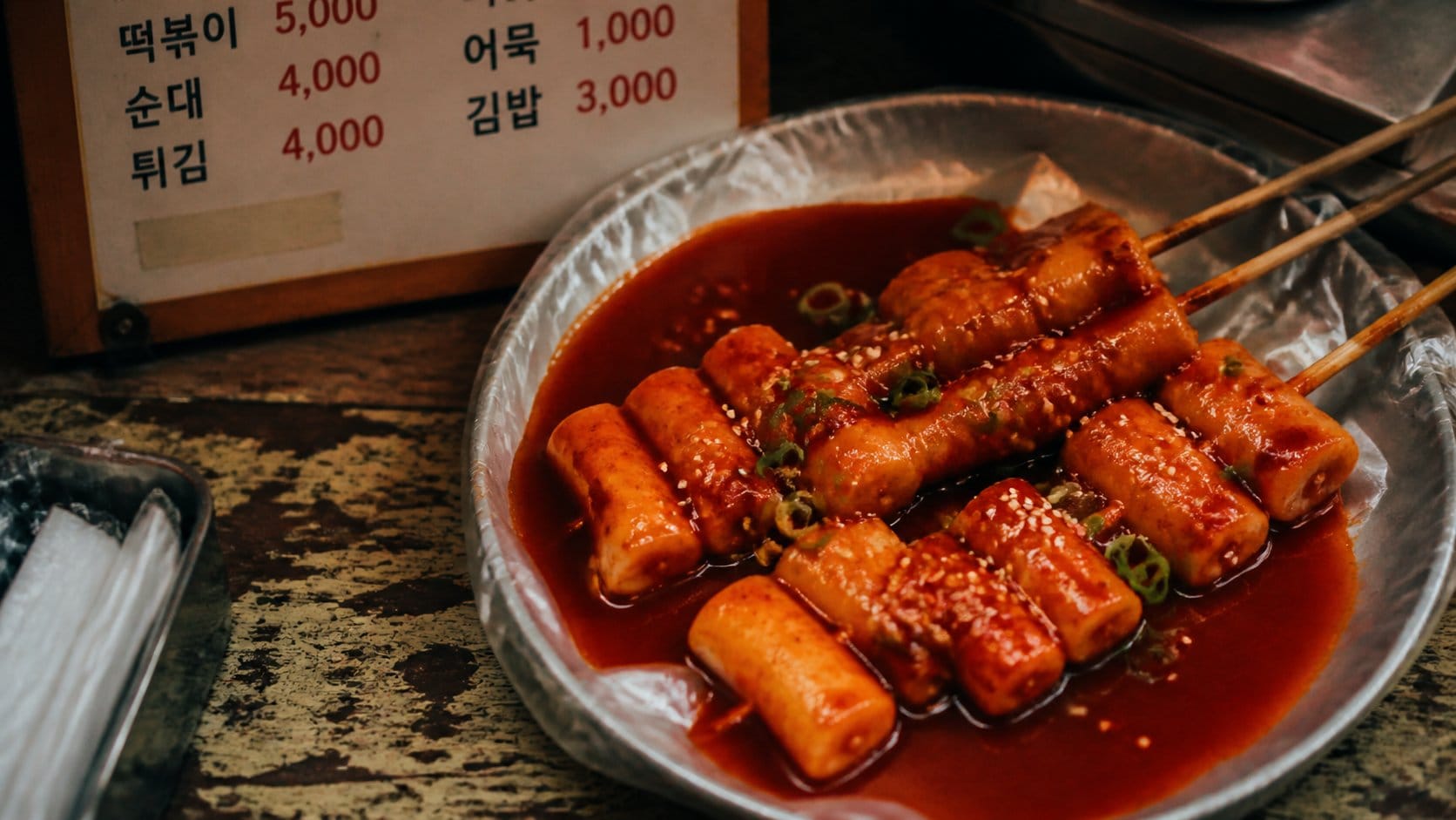 Tteokbokki rice cake skewers in red gochujang sauce