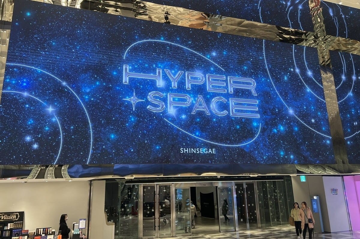 신세계백화점 센텀시티점 (storefront/exterior - 신세계 센텀시티 건물 외관 및 도로 전경, 파란 간판 보이는 건물 입구)