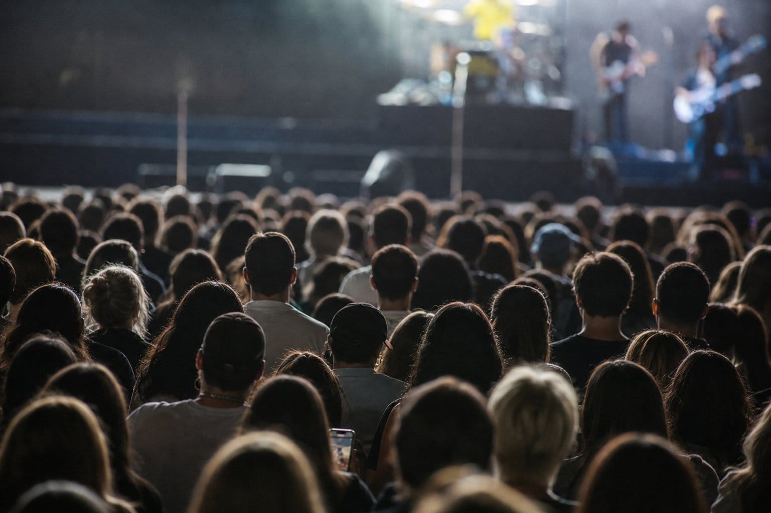 sold-out concert crowd with phones lowered