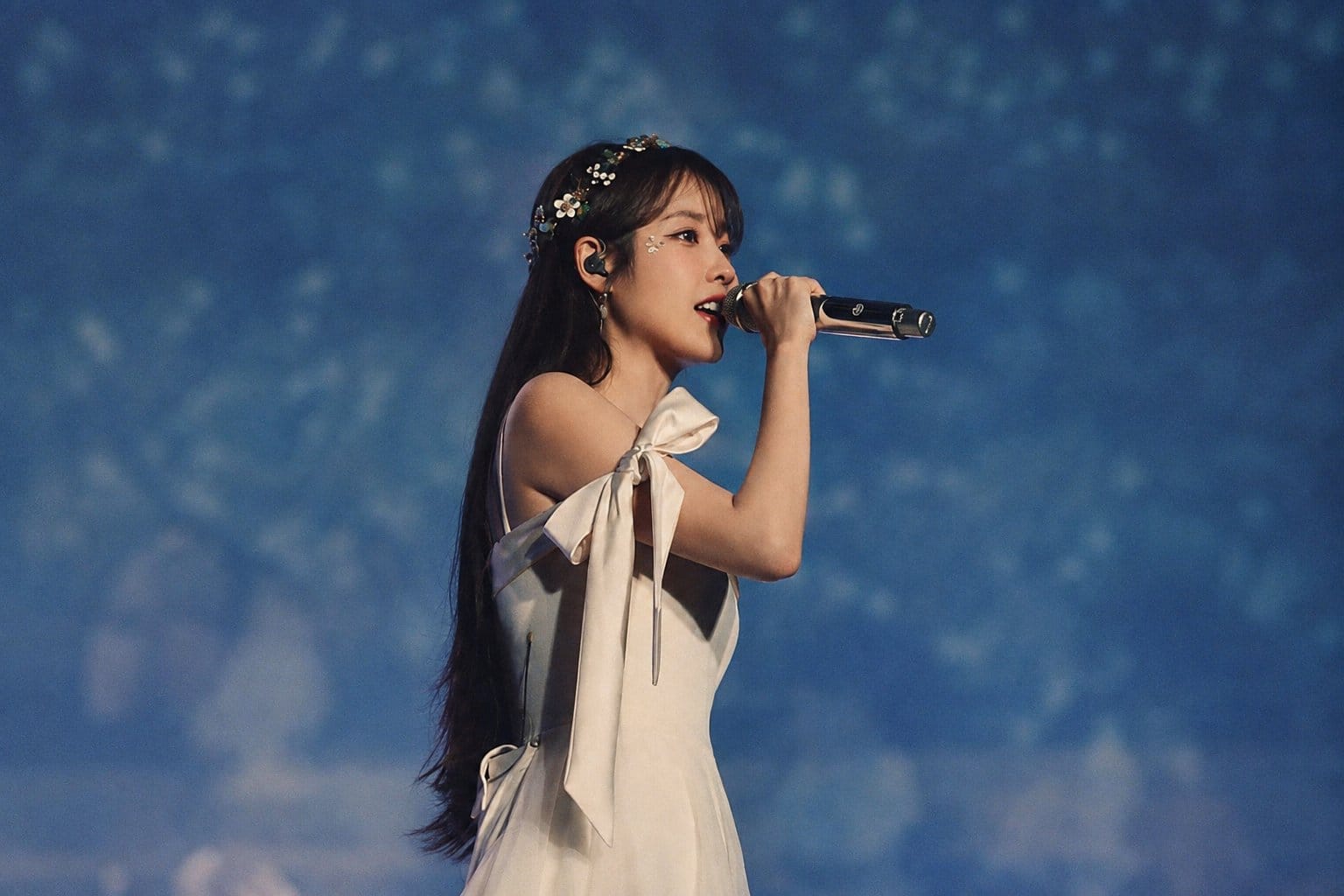 IU performing live on concert stage with microphone