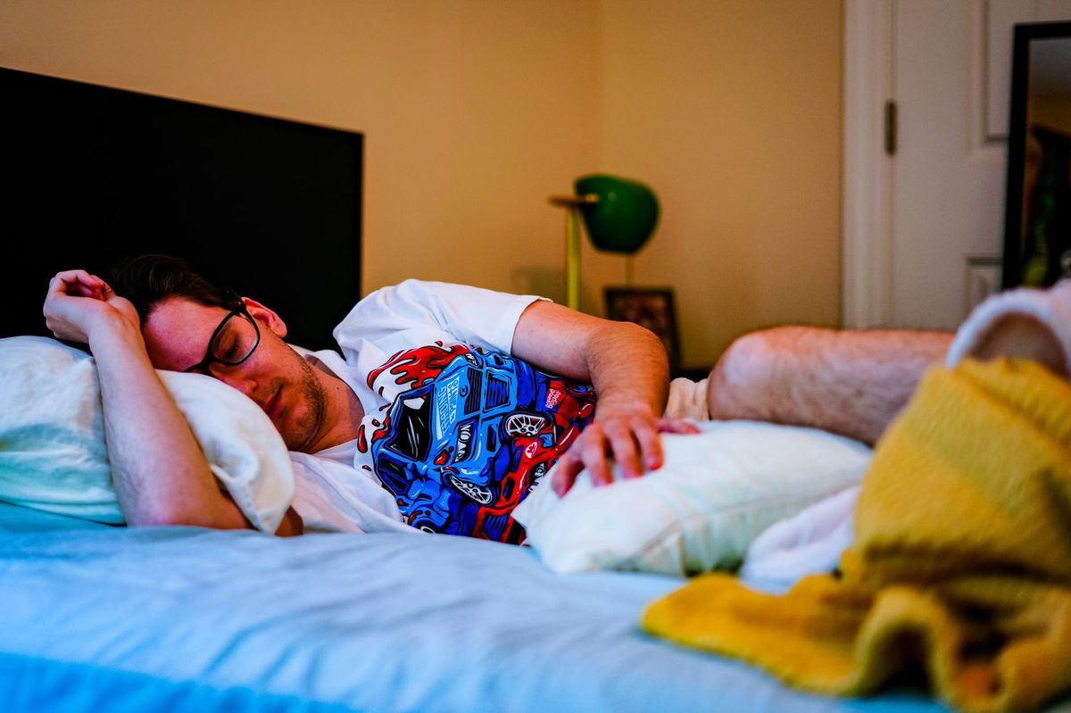 Ryan Williams, wearing a Trading Paints shirt, sleeping in a bed