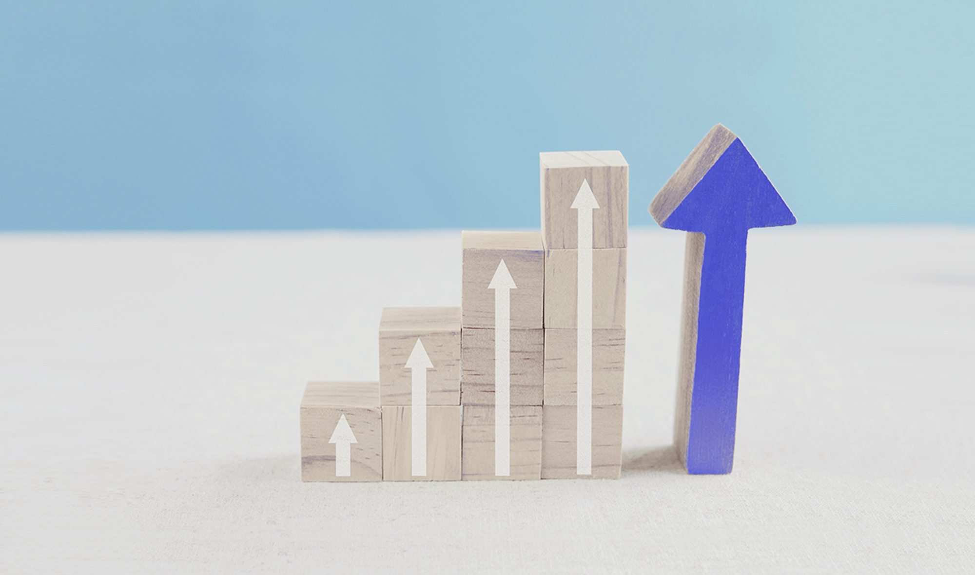 확장성 (Scalability)을 상징하는 화살표가 그려진 우드 블록들의 모습.