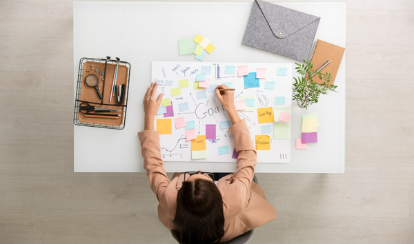 마케터가 큰 종이 위에 마케팅 자동화 목표를 쓰는 모습.