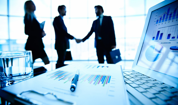 대기업 마케팅 관계자들이 악수를 나누고 있다. 그들의 앞에는 통계 차트가 펼쳐진 노트북, 자료, 물컵이 놓여져 있다.