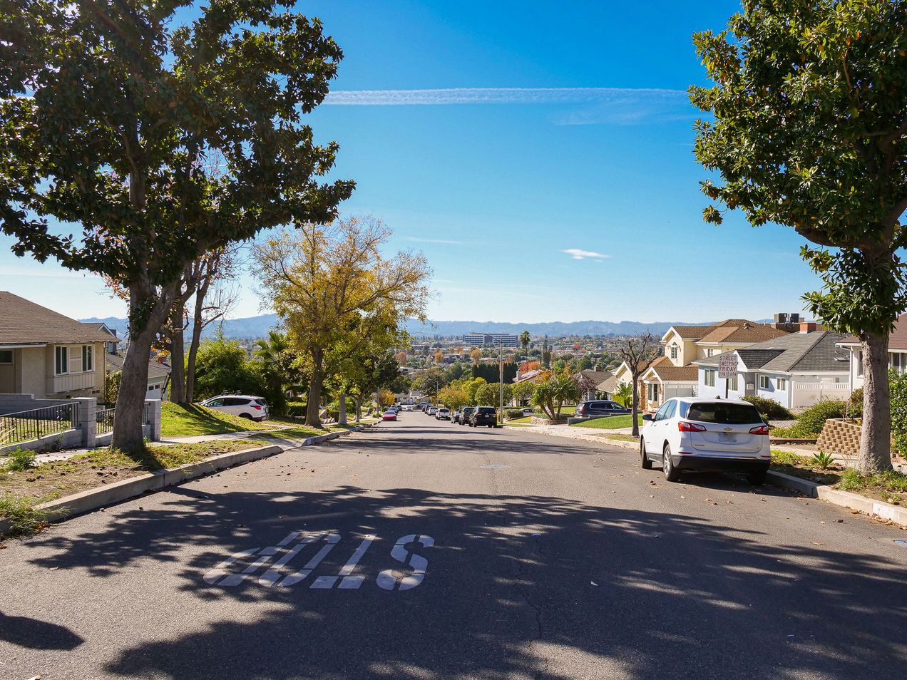 Nearly empty Burbank street on a Saturday. Trees and hills visible. 