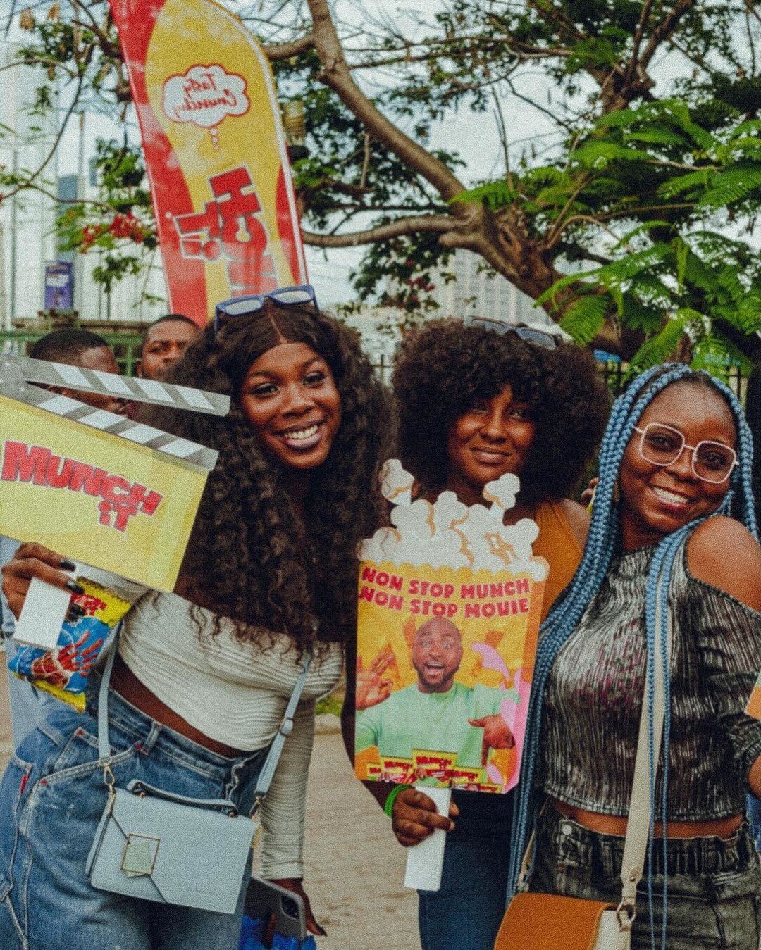 Attendees at the Movie in the Park Experience posing with Munch It product props