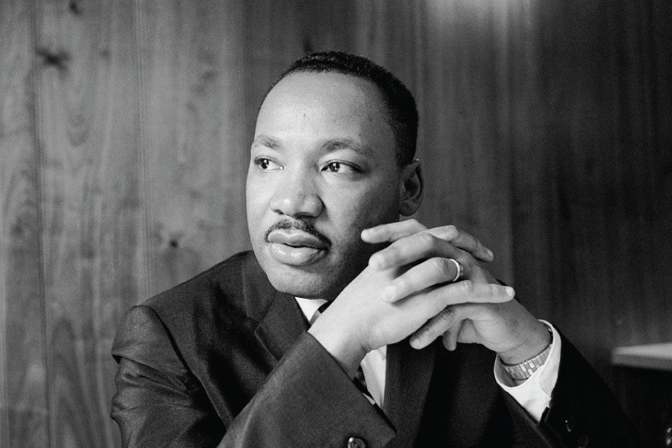 photo of Martin Luther King, looking away from camera, hands folded near face