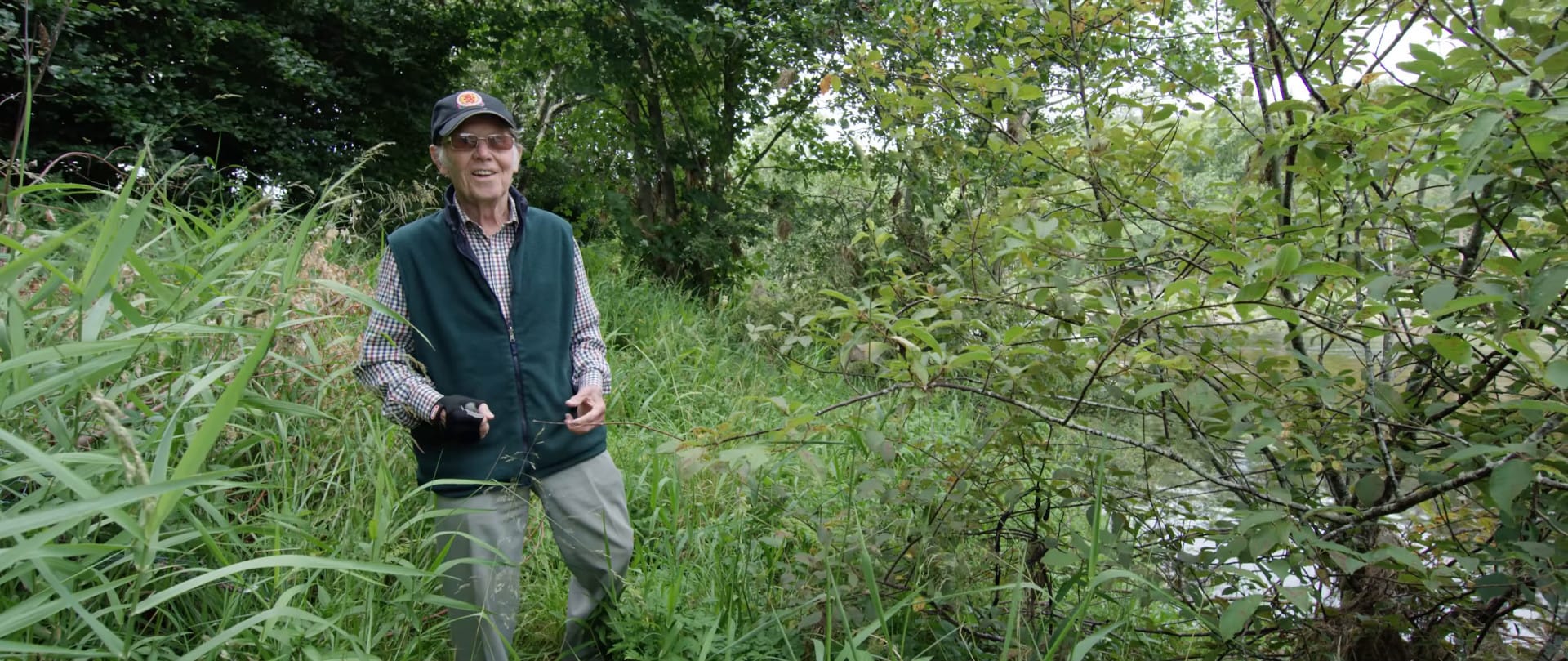 David Webster stands in an overgrown area on the bank of the River Dee.