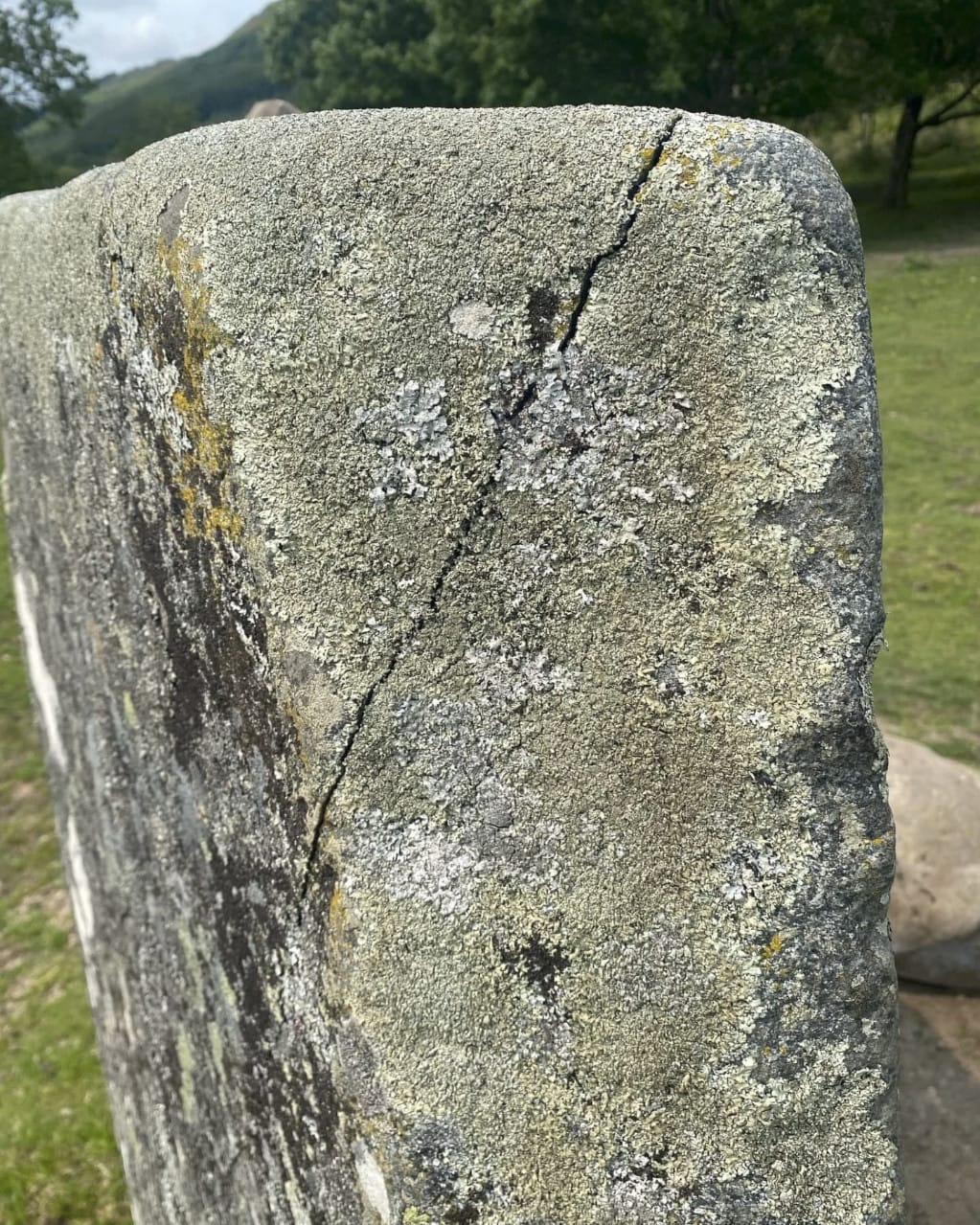 A photo of the Puidrac standing stone on the east side, a large crack from the top right to the bottom left is clearly visible.