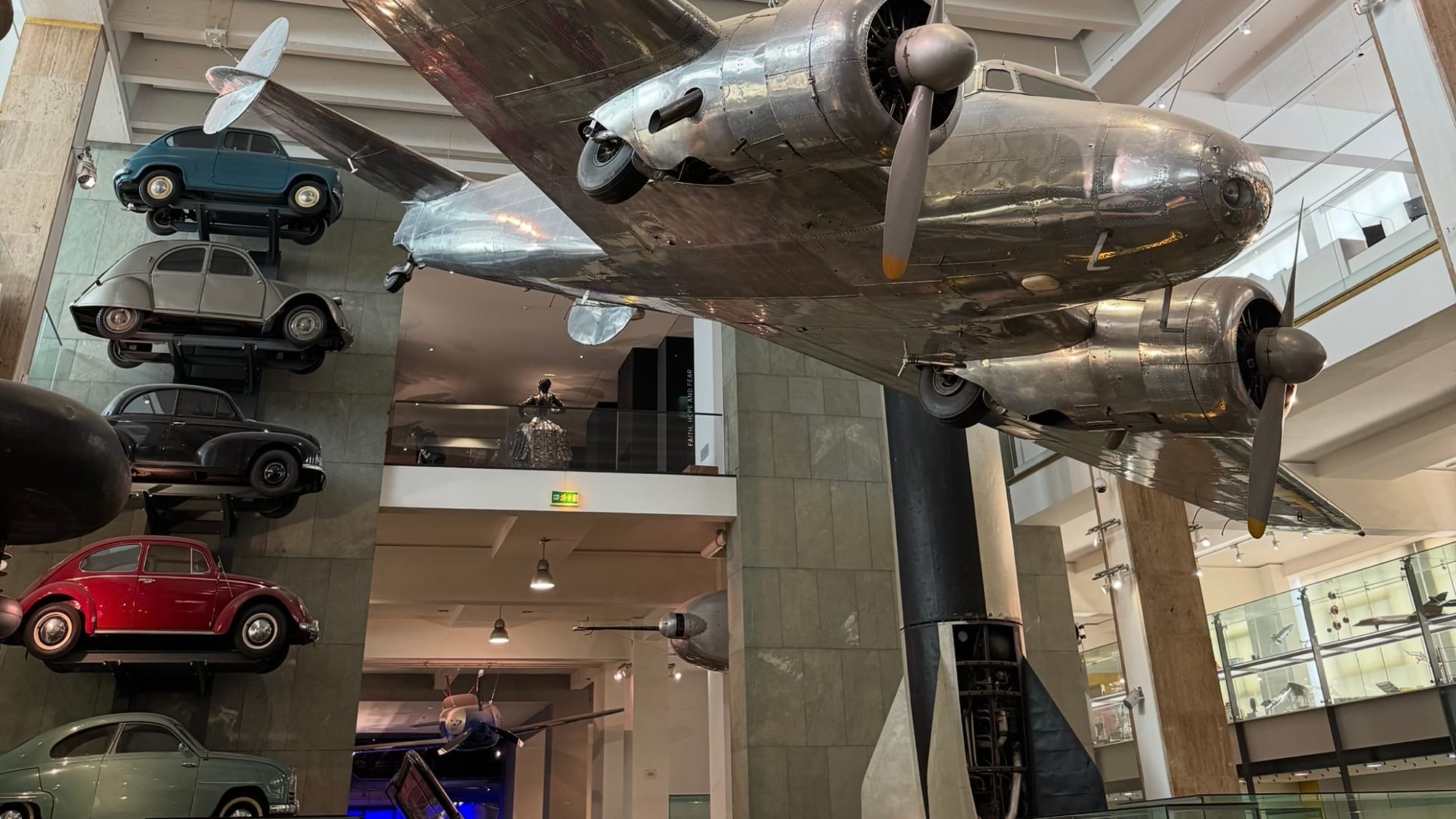 In the back of this image is an actual V-2 missile, a black and white rocket with some of the internals exposed.