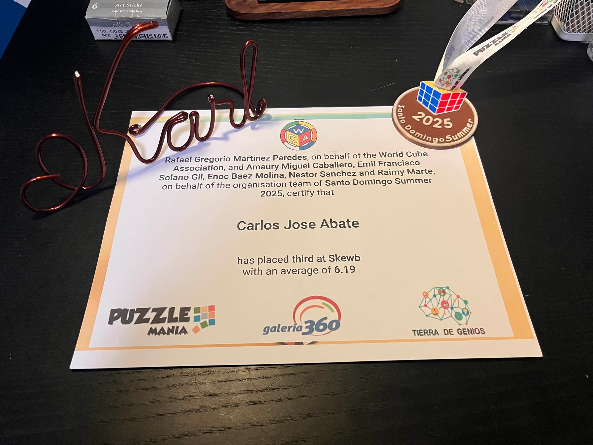 My Bronze medal, along with the complementary certificate! Also in the picture is a decorative strand of copper wire that spells out "Karl".