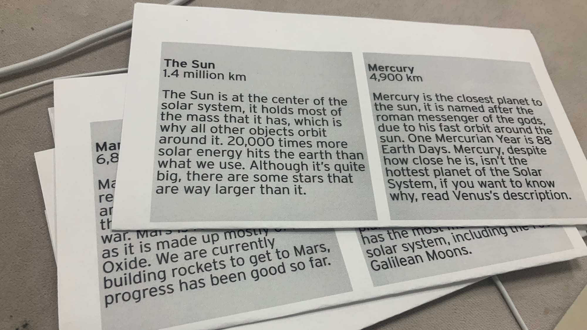 Sheets of paper with two blocks of text each. Each block contains information about an object in our Solar System, such as the Sun and Mercury.