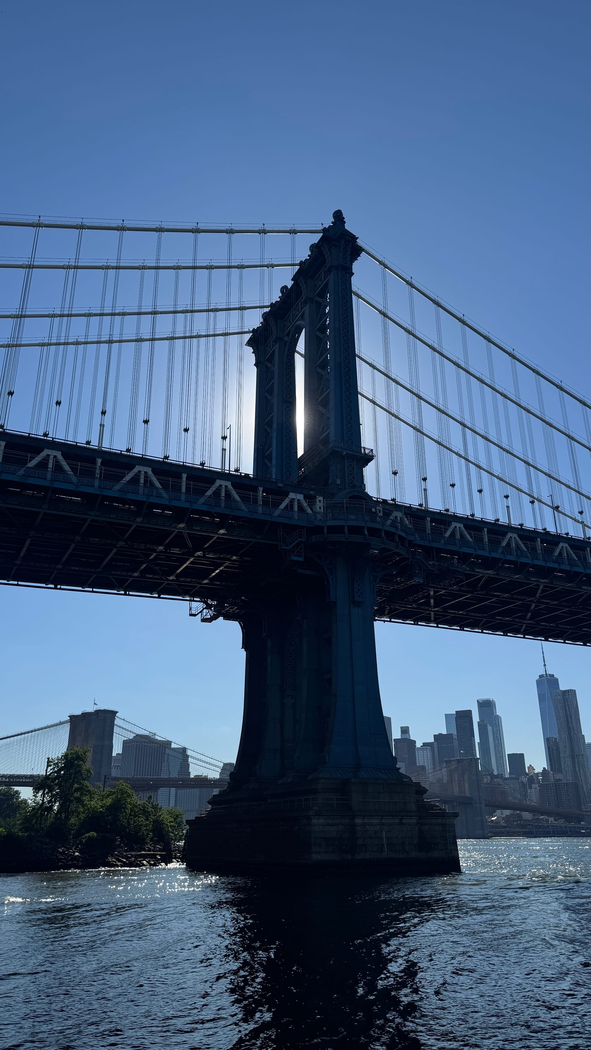 One of the supports of Manhattan Bridge in the East River, with the sun fitting perfectly in the gap.