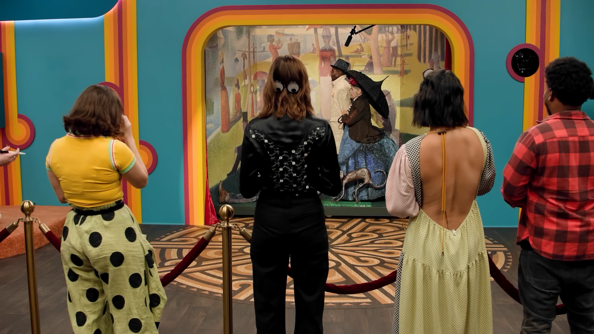 A screenshot of Game Changer S8Ep9, "I Spy". The contestants are standing in front of a live-action tableau based on A Sunday Afternoon on the Island of La Grande Jatte by Georges Seurat as it is revealed.
