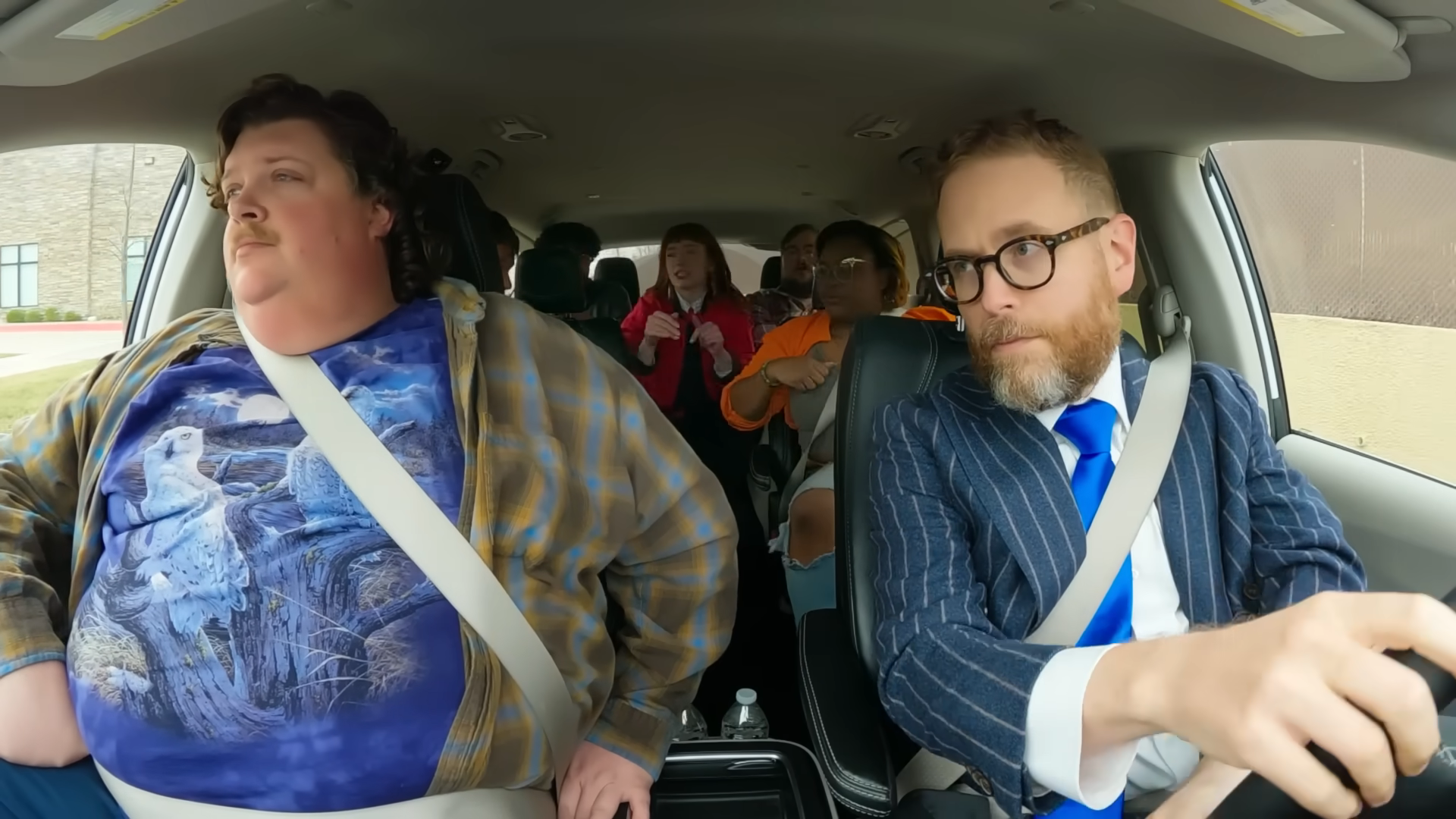 A screenshot from Game Changer S8Ep08, "What's The Catch". Sam Reich and Jacob Wysocki are in a car looking tired and annoyed along with the Your Little Dog 2 fake improv group.