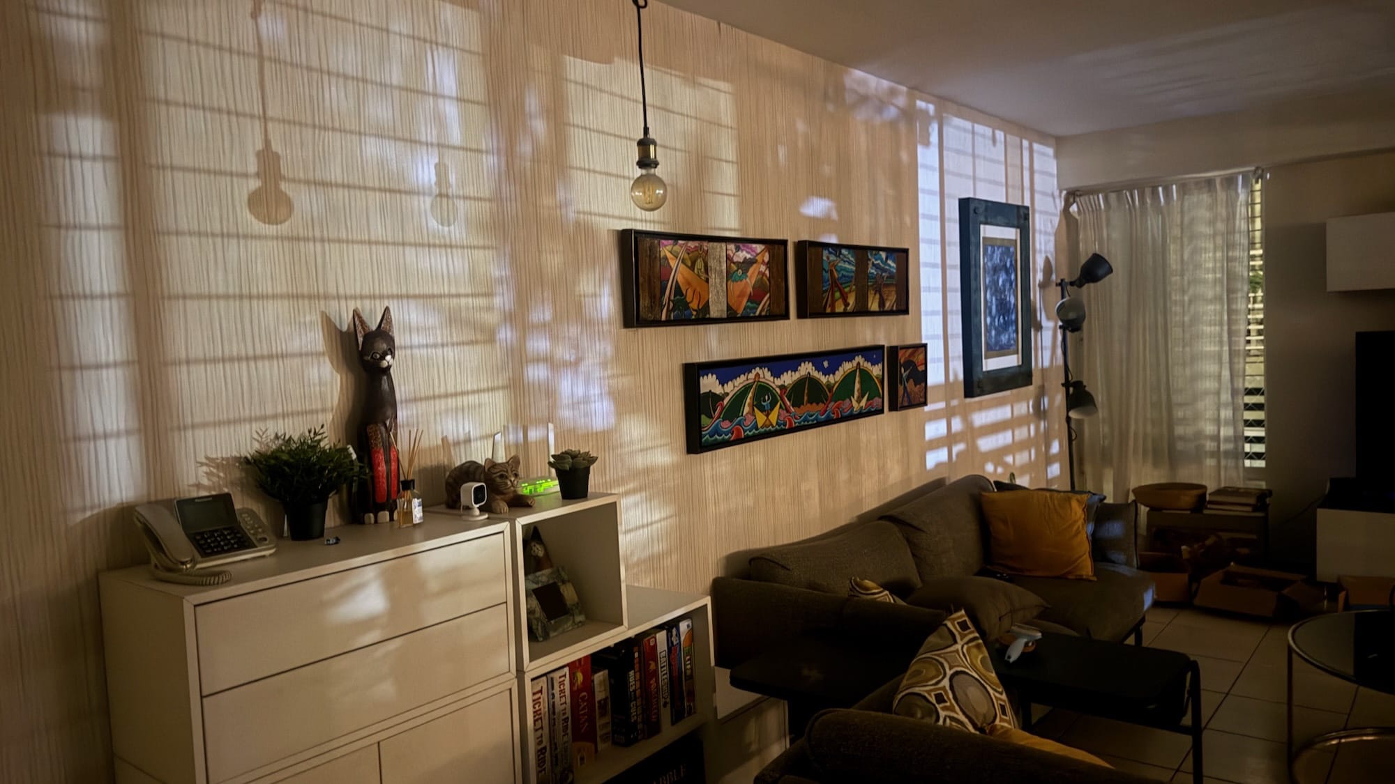 A high-exposure photo of my living room at night. There are some very clear lights and shadows caused by light from outside, specifically by the bars in the windows and balconies.