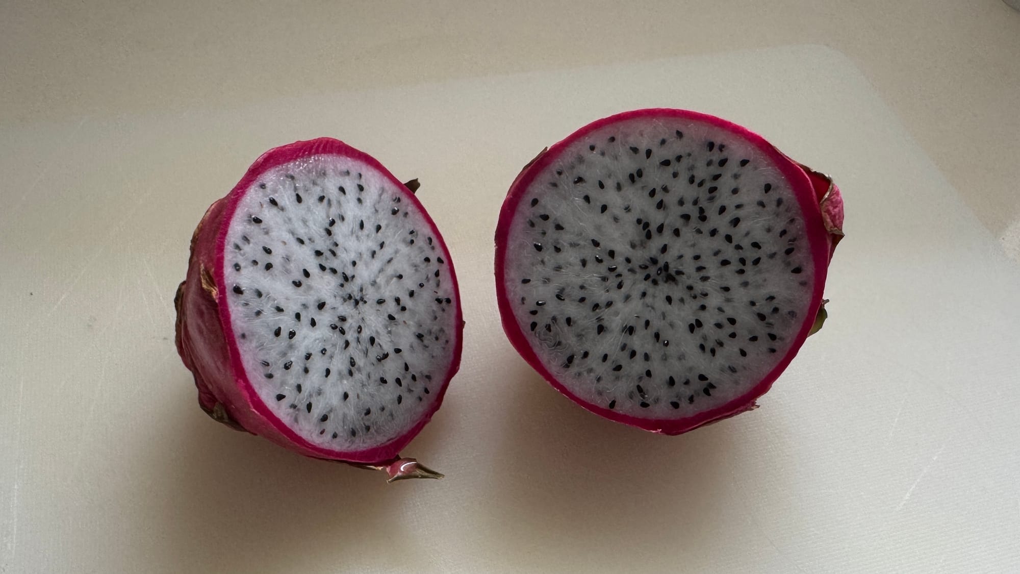 A sliced dragonfruit, showing its white flesh.