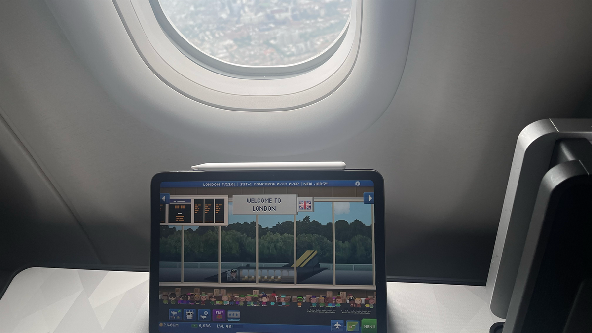 My iPad with the game Pocket Planes on, in front of the window behind literal actual London.
