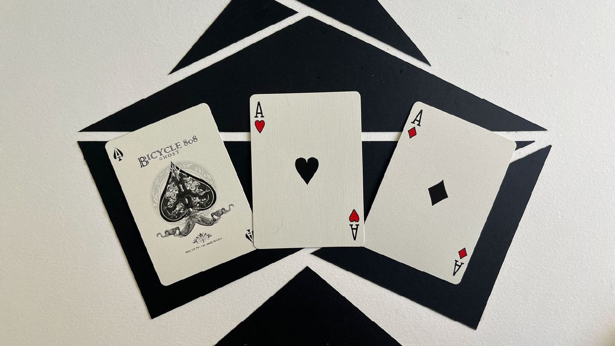 A black ace of spades, ace of hearts, and ace of diamonds.