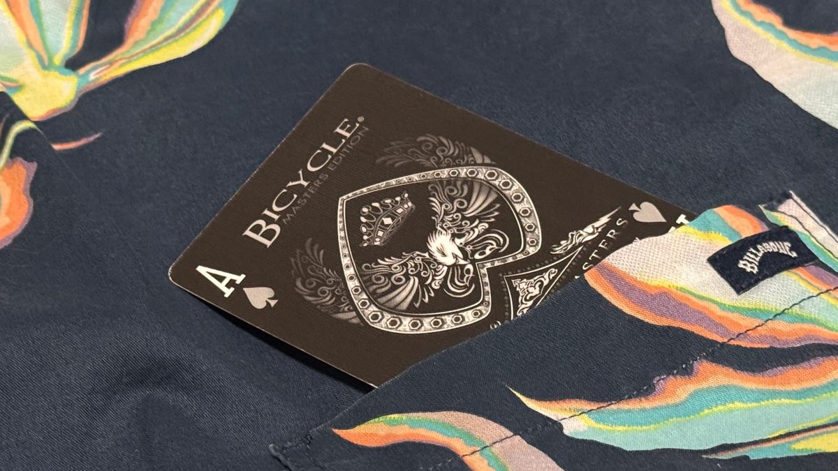 An ace of spades card from a Bicycle Shadow Masters deck inside of a Hawaiian shirt pocket.